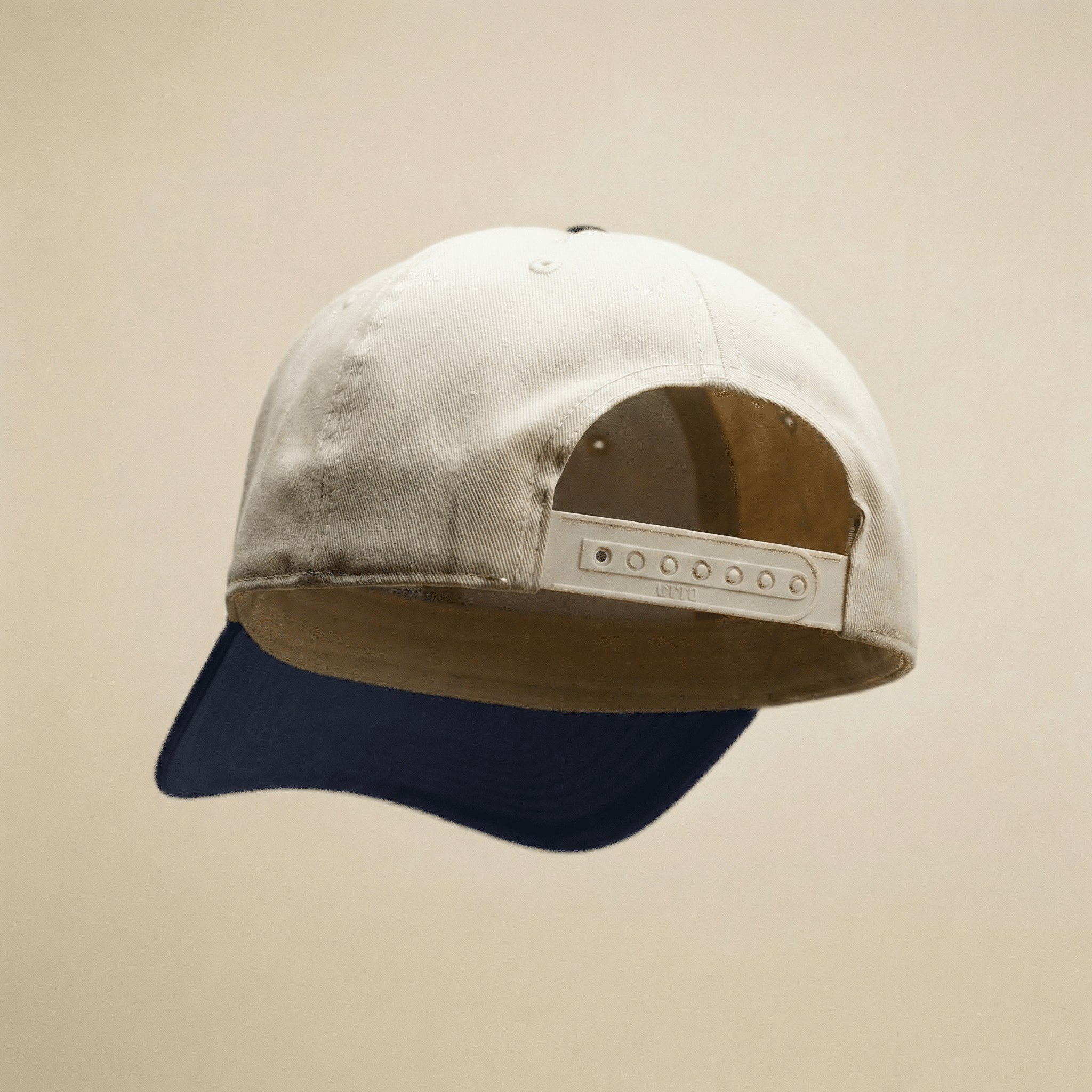 Two-tone cap with beige front and navy back on a beige background