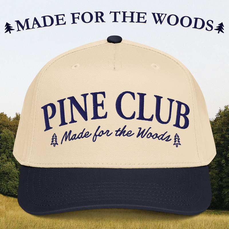 Beige and navy cap with 'Pine Club Made for the Woods' text against a forest background