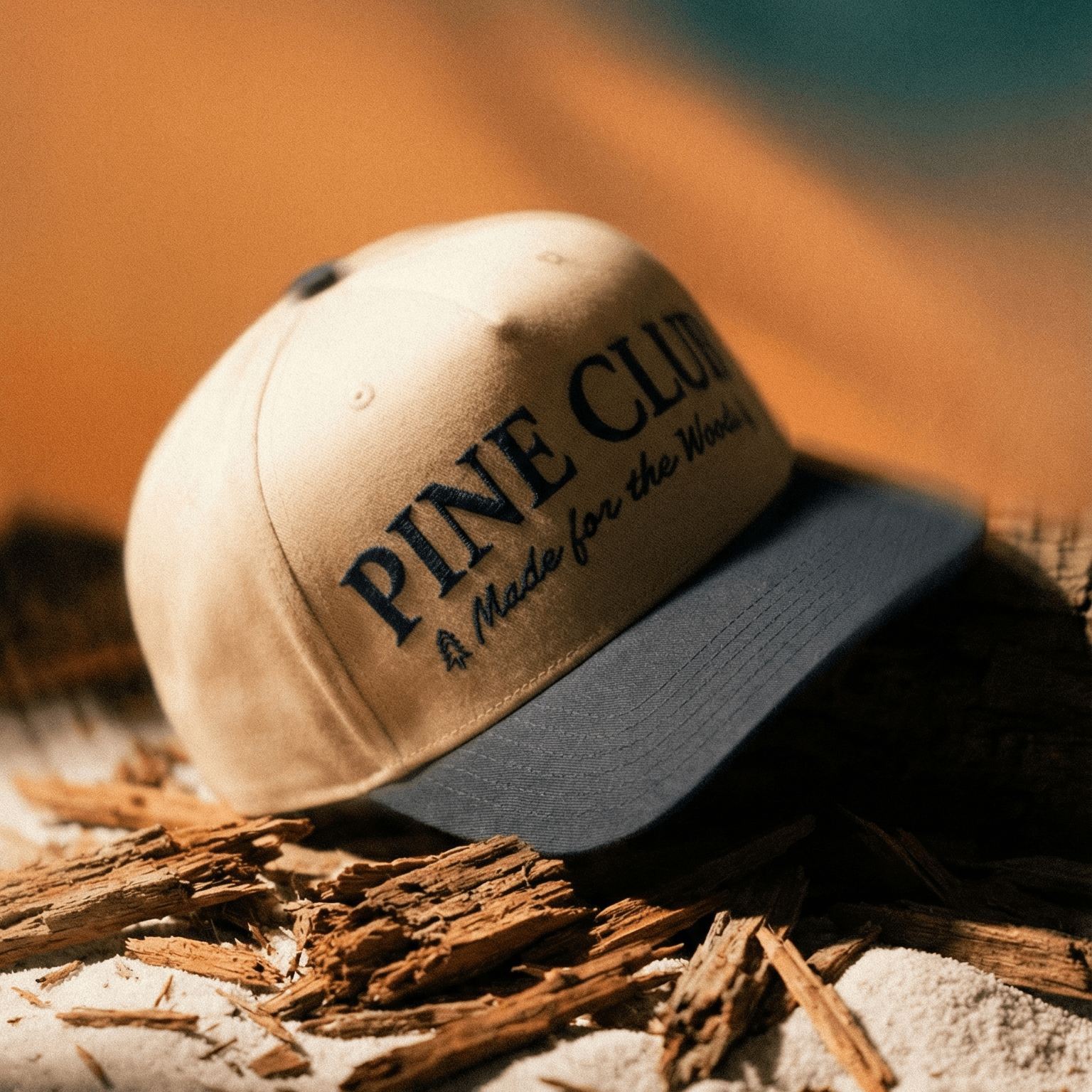 Cap with 'Pine Club' text on a textured surface with blurred background