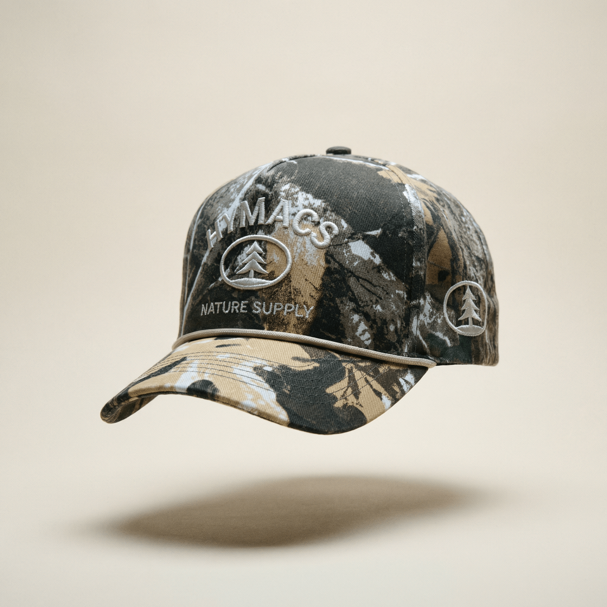 Camouflage baseball cap with 'Macs Nature Supply' branding on a beige background