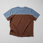 Two-tone brown and blue t-shirt on a light gray background