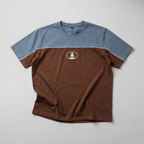 Two-tone blue and brown t-shirt with a logo on a gray background