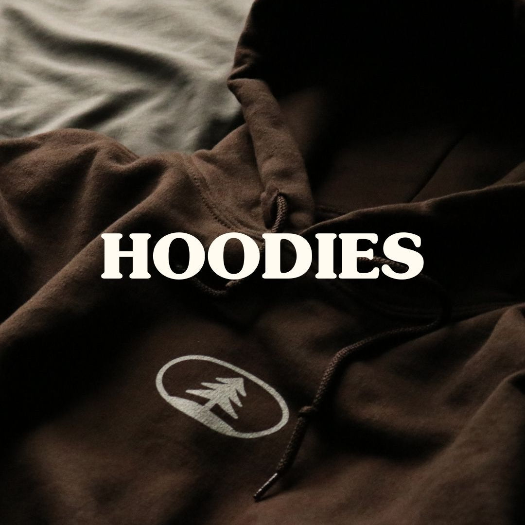 Brown hoodie with a logo on a bed, labeled 'HOODIES'.
